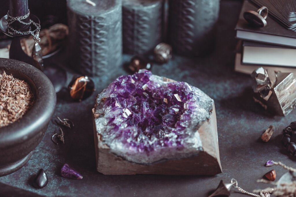 Amethyst Druze on a witch's altar for a magical ceremony among crystals and black candles.